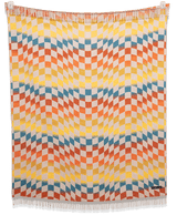 Checkered Santa Cruz blanket draped over a chair showing its geometric pattern and warm colors