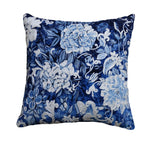Blue and white decorative throw pillow cover with embroidered design resting on a neutral-colored couch