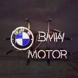 Neon light sign featuring the BMW roundel logo with blue and white quadrants on the left and white neon text reading 'BMW MOTOR' on the right, mounted on black metal frame.