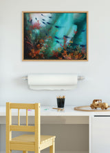 Abstract underwater scene with coral shapes in orange and red tones against swirling blue-green background, framed and hanging above a child's desk with chair and toys.