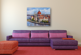 Colorful canvas painting of Budapest's Parliament along the river, hung above a purple sectional sofa with pink cushions in a modern living room.