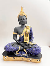 Seated Buddha statue with a black finish, detailed purple robe adorned with gold patterns and embedded rhinestones, and a golden headpiece, resting on a gold-trimmed base.