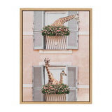 Framed canvas print featuring two giraffes peeking out from two stacked flower boxes with pink flowers, set against a peach wall with gray shutters on windows.