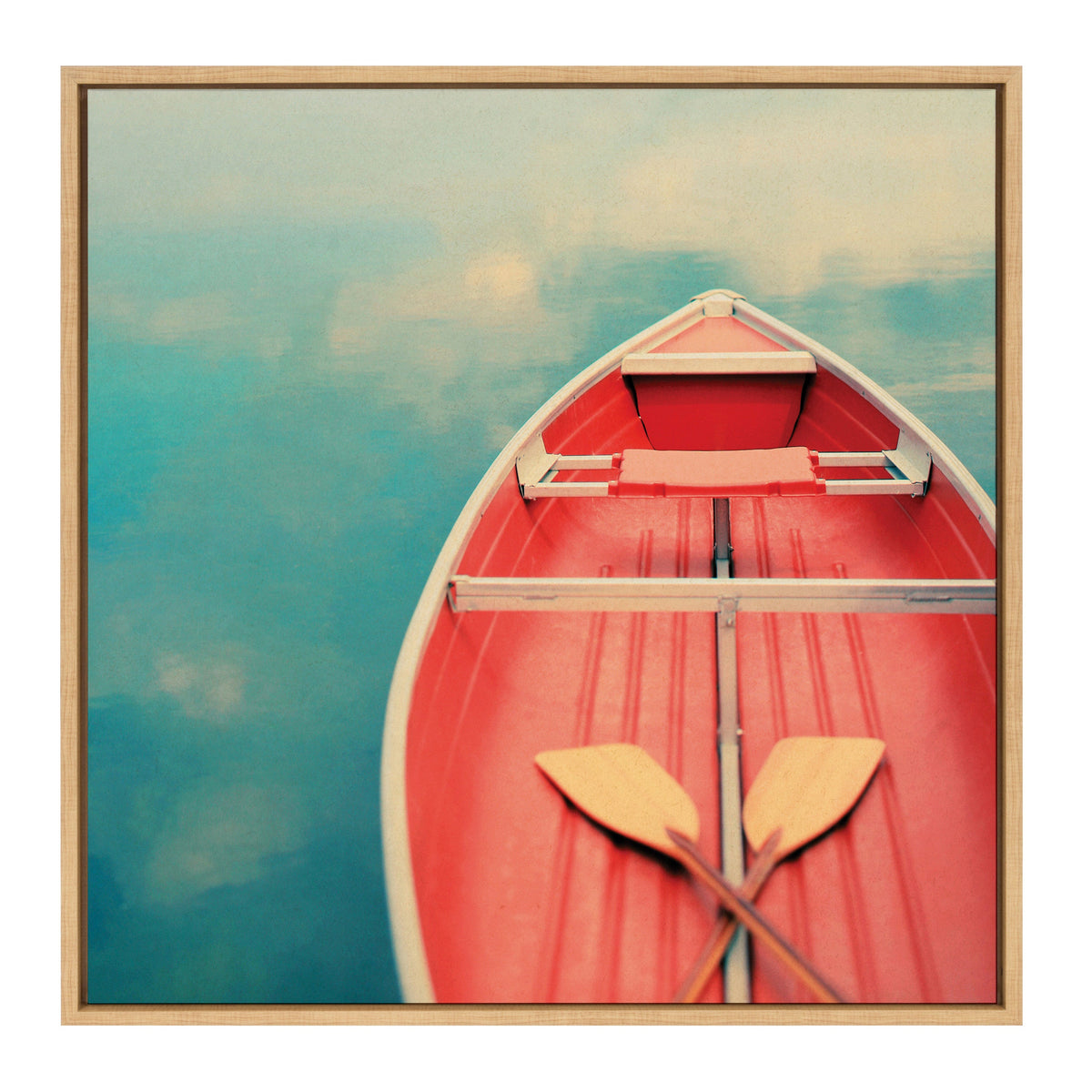 Top-down view of a red rowboat with two crossed wooden oars resting inside, floating peacefully on smooth blue water reflecting soft clouds.