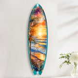 Tall surfboard-shaped wall art depicting a vibrant sunset over ocean waves with silhouetted palm trees and a colorful sky in shades of orange, purple, and blue.