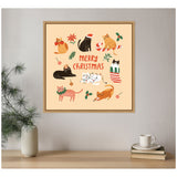 Framed Christmas-themed illustration of eight playful cats with holiday accessories surrounding red "Merry Christmas" text on a beige background, hanging on a gray wall above a wooden shelf.