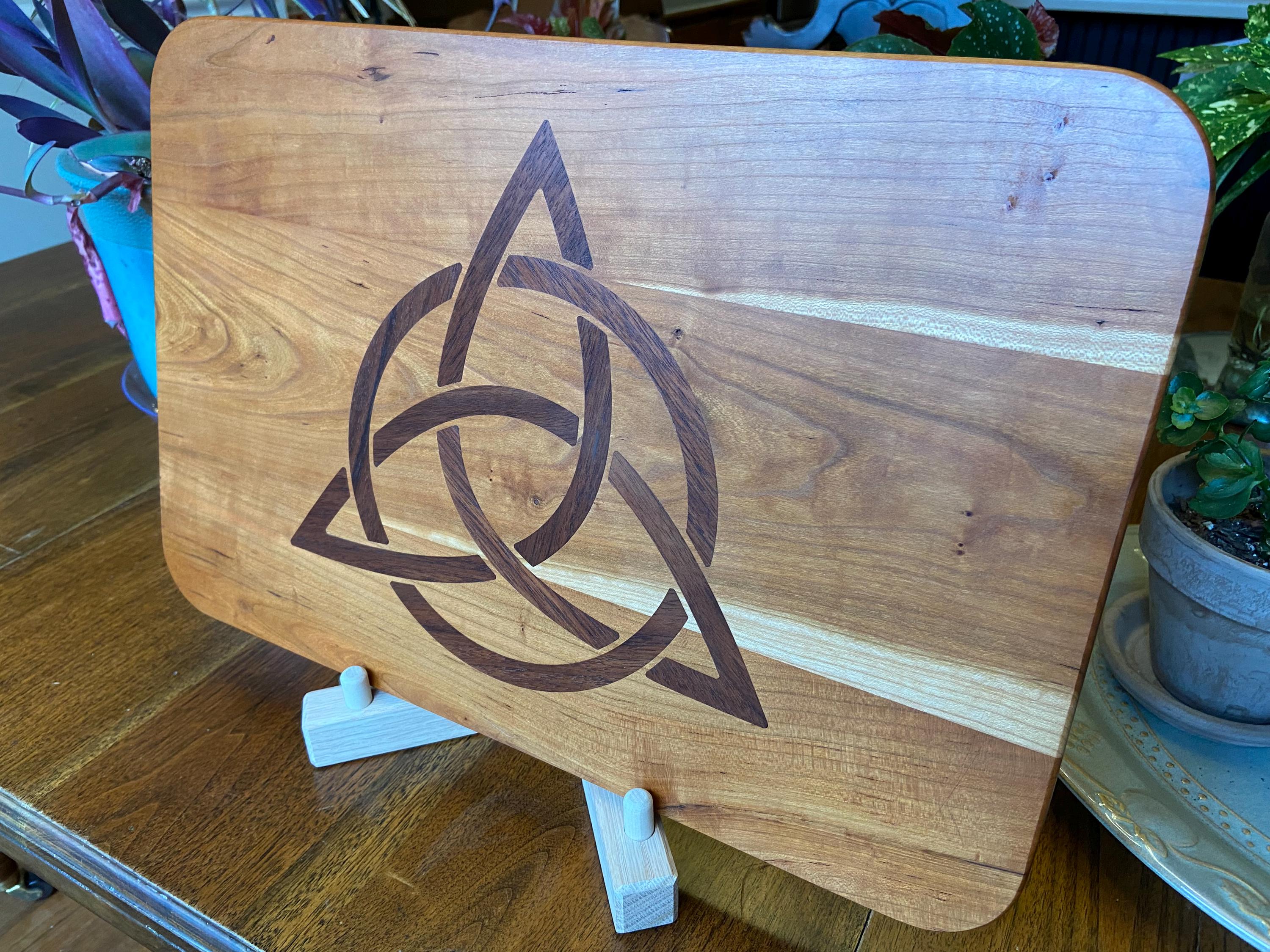 Cherry wood charcuterie board with Celtic Knot triquetra inlay made of Peruvian walnut