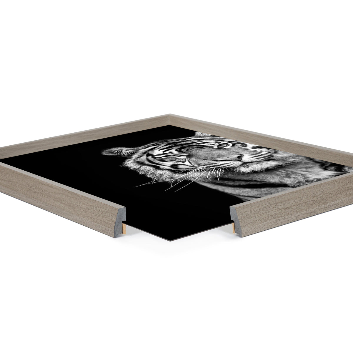 Close-up of a minimalist black and white tiger portrait print in a light wood frame with a mitered corner, against a white background.