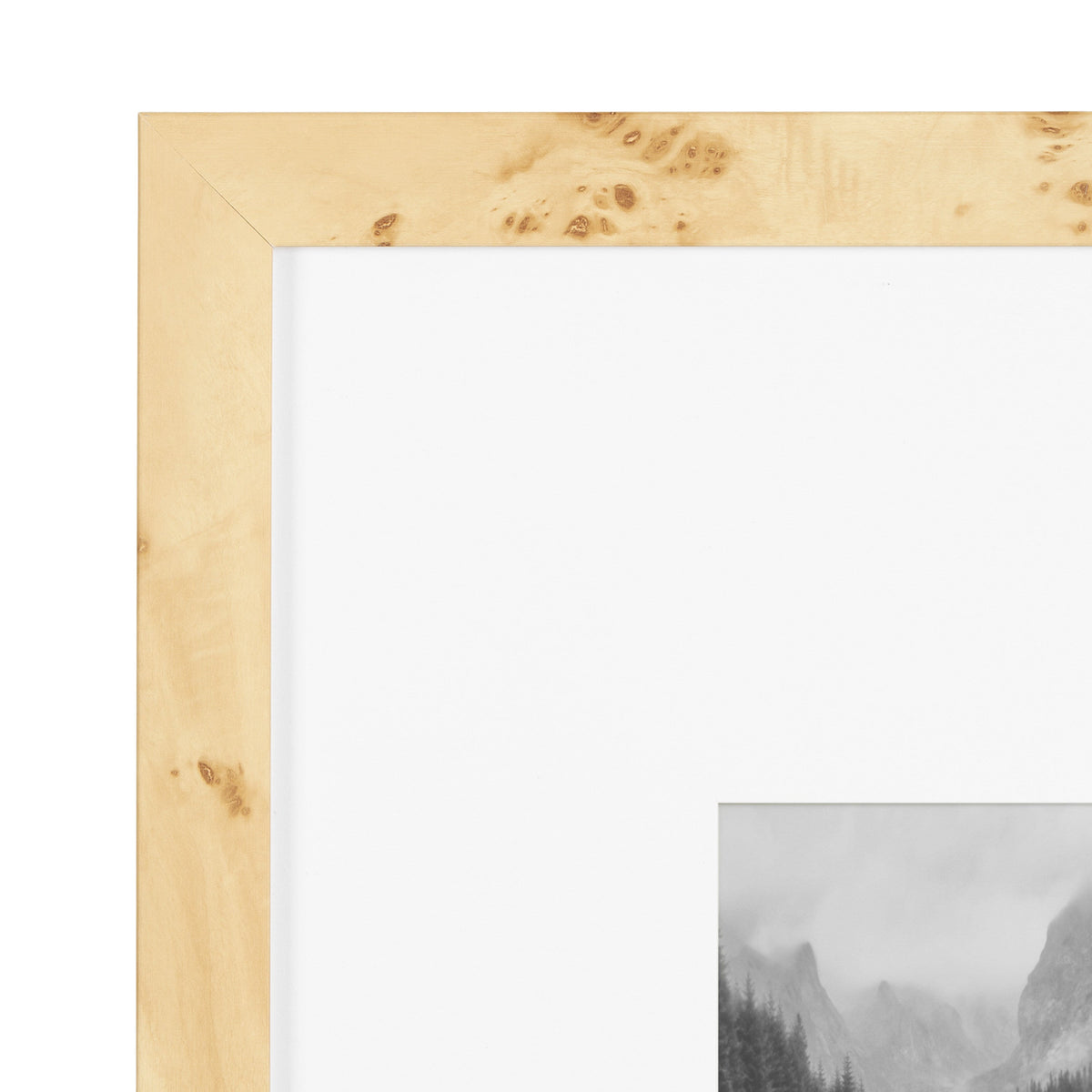 Light wood picture frame with natural burl wood grain, showcasing knots and swirls, surrounding a black-and-white mountain landscape photo.