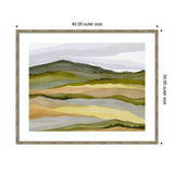 Abstract landscape painting with layered hills in muted greens, yellows, and browns under soft lavender and white sky, framed in light wood with white matting.