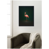 Framed wall art print featuring a side view of a pink flamingo against a deep green background, hanging above a dark olive armchair draped with a chunky cream knit blanket.