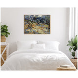 Vincent van Gogh's Olive Trees painting with twisting dark branches and blue-green foliage, framed and hung above a white bed in a sunlit minimalist bedroom.