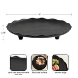 Black sand-cast textured metal decorative tray with deckled edge and three short feet, measuring 16 inches wide and 2.75 inches tall.