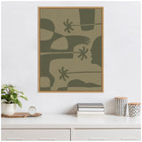 Framed minimalist canvas art featuring abstract olive green organic shapes and silhouettes on a beige background, hanging above a white cabinet with decor items.