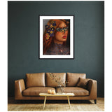 Framed portrait of a woman with red hair adorned by colorful flowers and a detailed butterfly mask, set against a dark textured wall above a brown leather sofa.