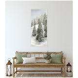 Vertical canvas painting of snow-covered evergreen trees in a misty winter landscape, framed with delicate beaded trim, hanging above a wooden bench with green and white cushions.