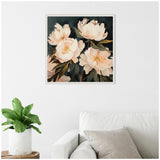 Framed painting of soft pink and white peony flowers with dark green leaves on a deep navy background, hanging on a white wall above a white sofa with a gray pillow.