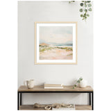 Framed square wall art of a soft, pastel-hued beach landscape with sandy foreground, greenish dunes, and a pale blue sky, displayed above a wooden console with decor.