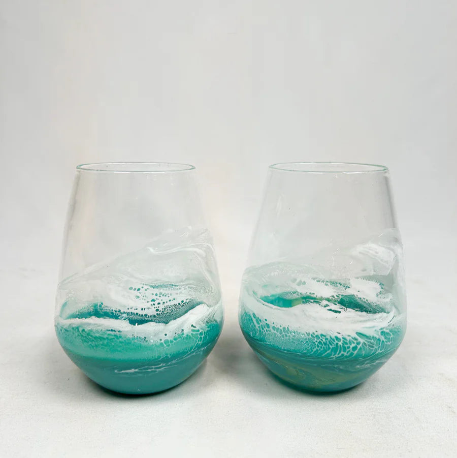 Two stemless resin wine glasses with blue and white ocean wave design on a white background