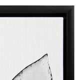 Close-up of a black-framed canvas featuring a minimalist black and white abstract succulent leaf with textured fabric background.