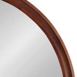 Partial view of a round wall mirror with a smooth, medium brown wooden frame featuring subtle grain patterns and a slightly beveled inner edge.