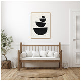 Minimalist living room with wooden bench seating white cushions, natural woven round rug, potted plant, and framed black geometric shapes on white wall