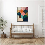 Framed abstract canvas with overlapping jewel-toned arches in pink, teal, blue, and mustard hues hangs on white wall above wooden bench with white cushions in minimalist room.