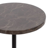 Close-up of round brown marble tabletop with light beige veining on a black cylindrical metal stand.