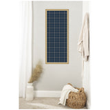 Tall rectangular fabric pinboard with navy blue plaid pattern framed in light wood, mounted on a neutral wall above a wicker basket and decorative vase with dried pampas.