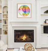 Colorful mosaic disco ball artwork in a natural wood frame hangs above a lit gas fireplace flanked by built-in white shelves with decor items.