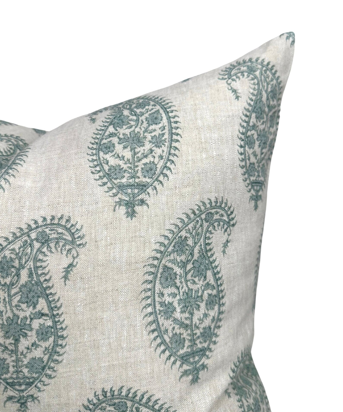 Close-up of a beige pillow cover featuring celadon green paisley patterns with intricate floral details embroidered on textured fabric.