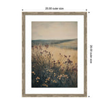 Framed print of a soft landscape with wildflowers in the foreground and rolling hills in muted tones under a cloudy sky.