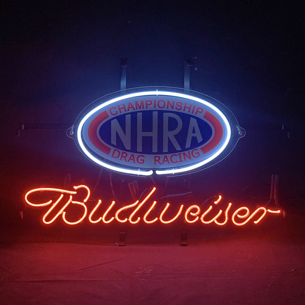 Oval neon sign with 'CHAMPIONSHIP NHRA DRAG RACING' in red and blue above glowing orange-red cursive 'Budweiser' lettering on a dark background