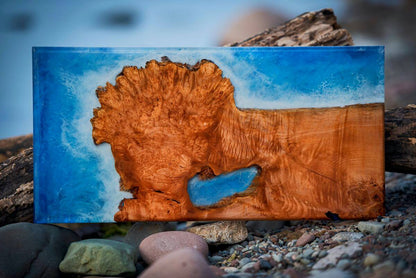 Wooden plaque with a natural wood texture and blue accent on a blurred natural background