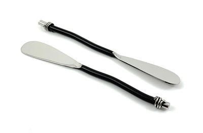 Set of six Vibhsa black silverware butter spreaders resting on a wooden surface alongside cheese and crackers