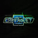 Neon sign shaped like a Chevrolet bowtie emblem, glowing blue with white neon letters spelling CHEVROLET inside the shape on a black background.