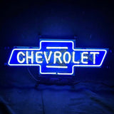 Bright blue neon sign shaped like a Chevrolet bowtie logo with 'CHEVROLET' glowing in white neon letters centered inside the blue outline on a dark background.