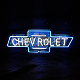 Neon sign of the Chevrolet logo with blue outline and white inner text spelling CHEVROLET on a dark background