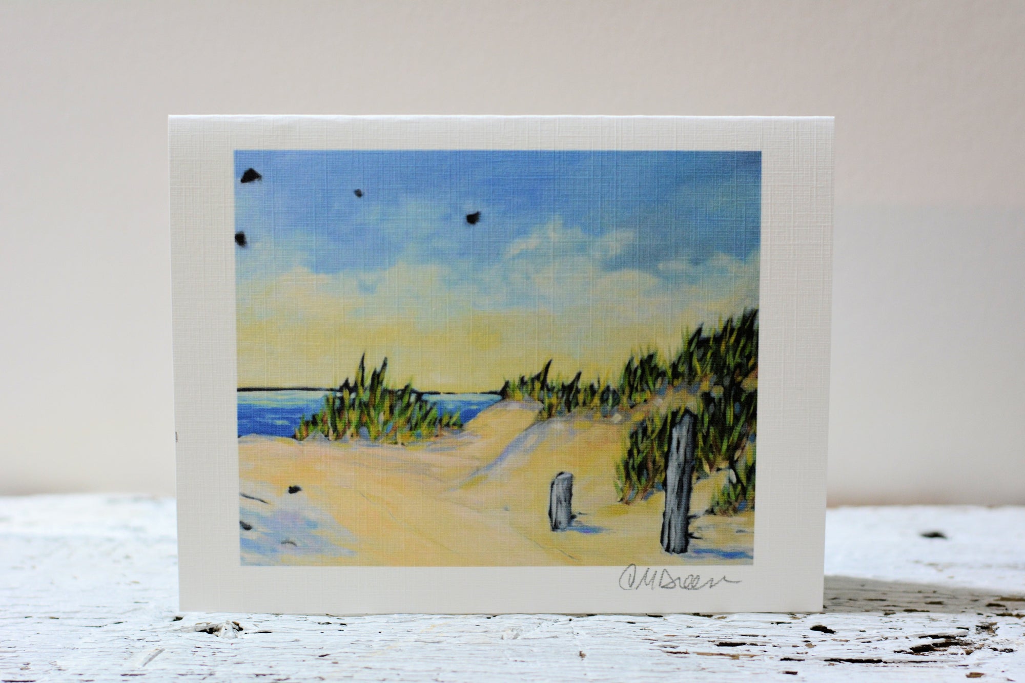 Notecard 'Peace at the Lake' featuring a serene lake scene, displayed face up on linen textured paper
