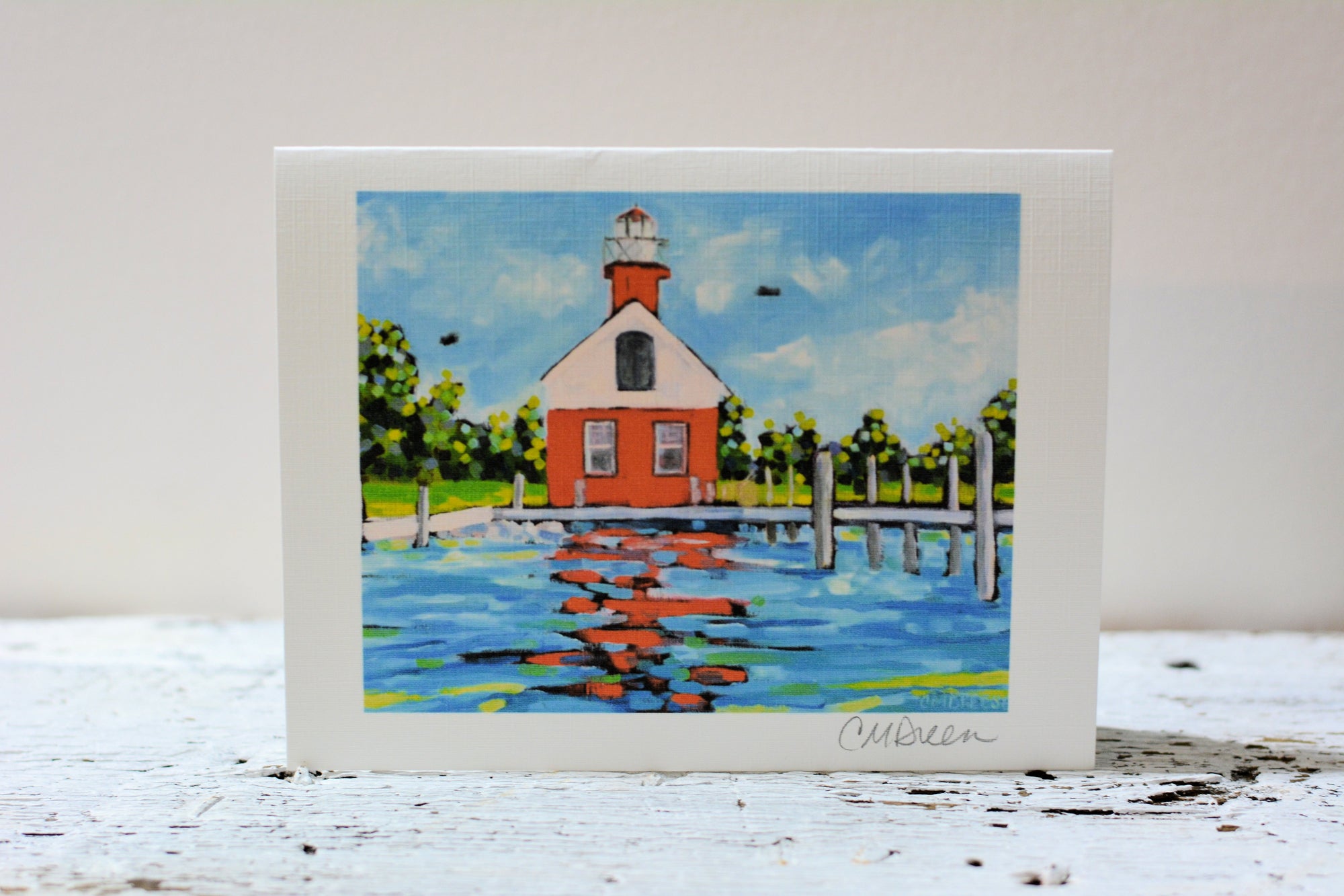 Notecards - Saugatuck Lighthouse featuring artwork of a lighthouse, staged on a wooden surface.