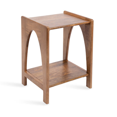 Aarstad Wood Side Table in natural finish shown with a lower shelf holding books and a top surface with minimal decor in a living room
