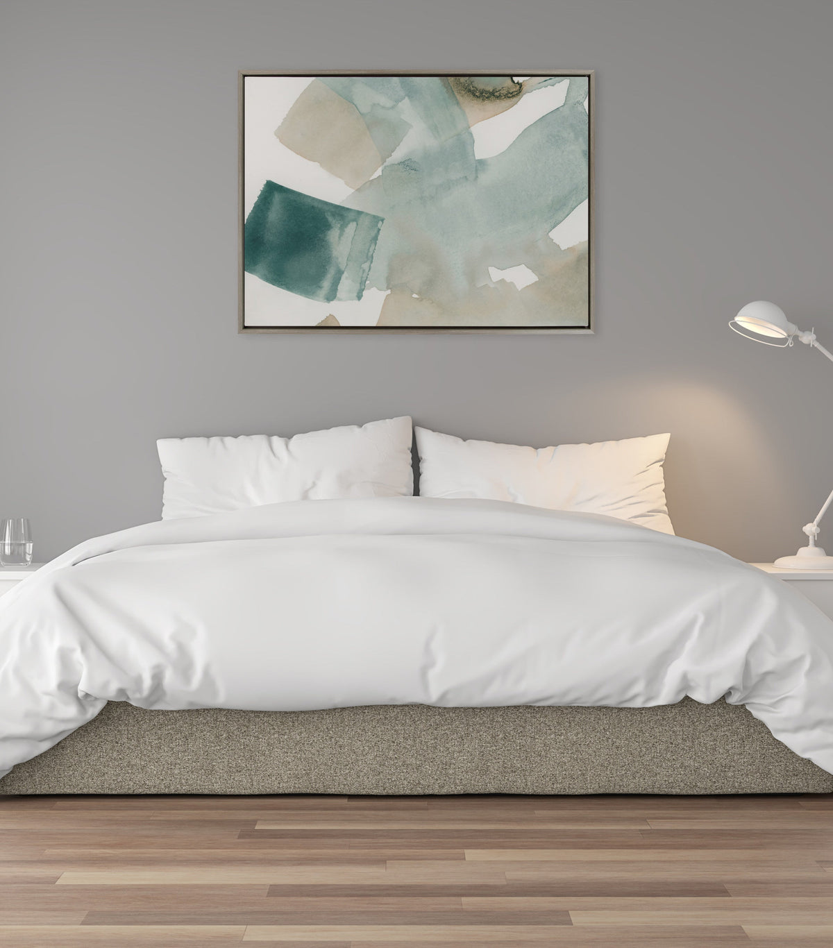 Abstract painting in muted teal and beige watercolor brushstrokes in a wooden frame hangs centered above a bed with white bedding against a gray wall.