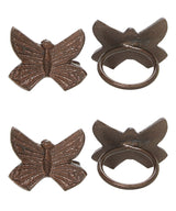 Four antique bronze-toned butterfly-shaped napkin rings with detailed engraved wings and circular bands visible from front and back views on white background.