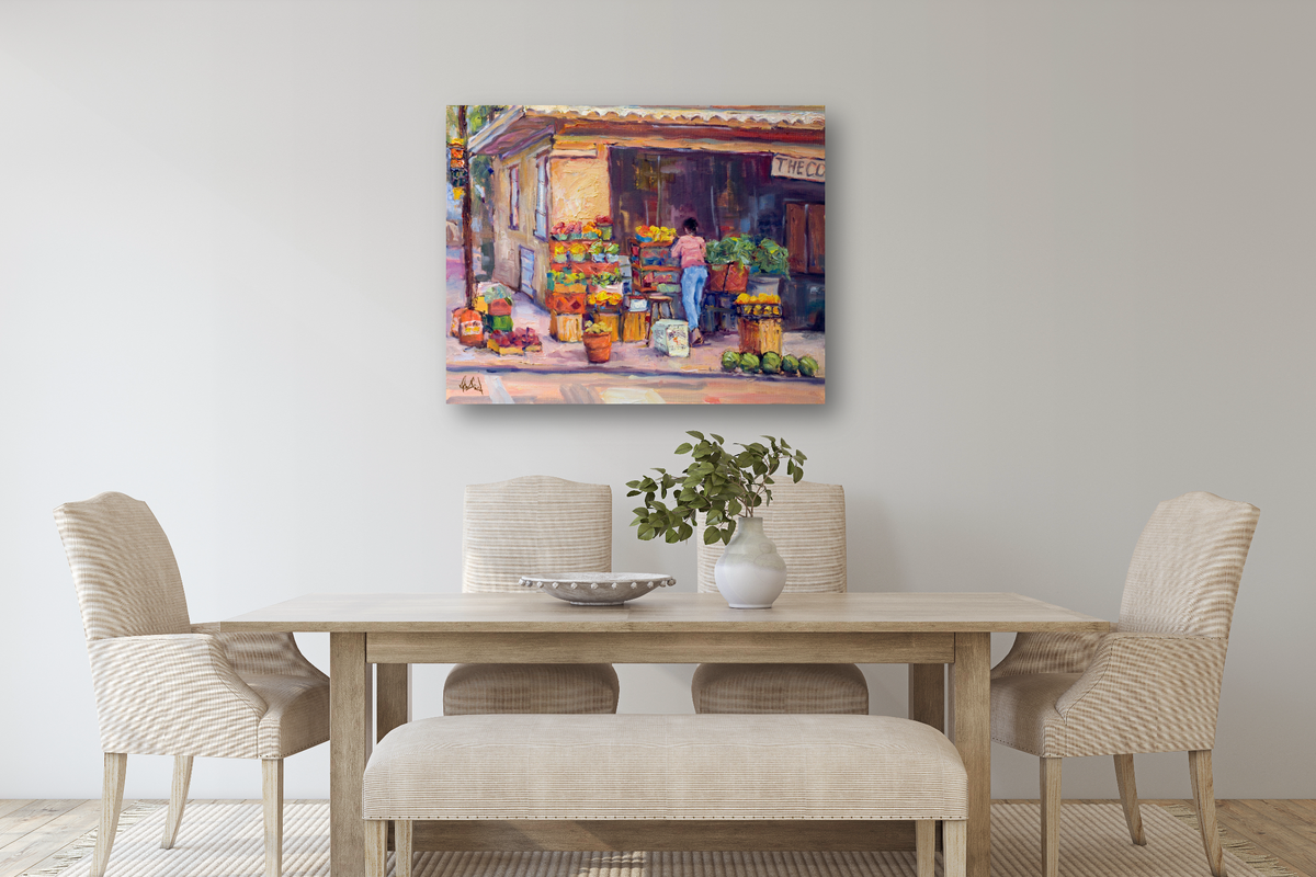 Painting of a colorful corner market scene with crates of fruit and a person standing near the entrance, displayed above a beige dining table with four chairs and a bench.