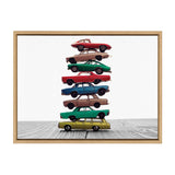 Stack of eight colorful vintage toy cars arranged vertically on a light wood surface with a white background, framed in natural wood.