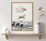 Framed canvas print of a gray elephant floating over Paris rooftops, lifted by pastel pink, blue, and green balloons against a pale sky.