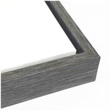 Close-up of a gray wood grain picture frame corner with visible canvas texture inside the frame on a white background
