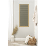 Tall rectangular framed pinboard with sage green and beige plaid fabric, mounted on a light gray wall above a wicker basket and white vase with dried grass.