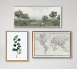 Three framed artworks on a white wall: a horizontal impressionist landscape with muted greens and grays, a vertical botanical print of eucalyptus leaves, and a vintage-style black and white world map.