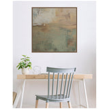 Abstract framed canvas wall art with sage green, beige, and brown hues, featuring textured brushstrokes, hanging above a wooden desk with a gray chair and potted plant.